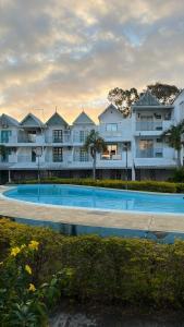 un grande edificio con una piscina di fronte di Pereybere 3 Bedroom Beach Apartment a Grand Baie