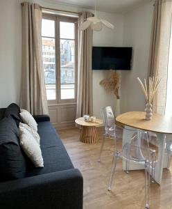 a living room with a blue couch and a table at Le petit Rameau - T2 hypercentre in Clermont-Ferrand