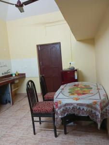 a table and a chair in a room with a table and a table at Ashpil House Guest House Margao South Goa in Navelim
