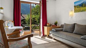 a living room with a couch and a sliding glass door at Hotel Effland -Sauna -Pool in Bayrischzell