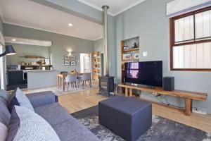 Una sala de estar con un sofá y un televisor. en Two Penguins, en Ciudad del Cabo