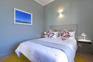Un dormitorio con una cama blanca con almohadas. en Two Penguins, en Ciudad del Cabo 18 fotos más