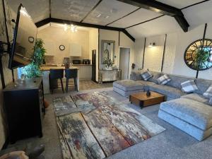 a living room with a couch and a kitchen at The Coach House at The Bull Inn in Milton Keynes