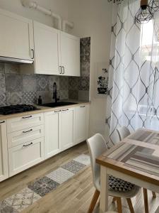 a kitchen with white cabinets and a table with chairs at Casa Rebocco in La Spezia