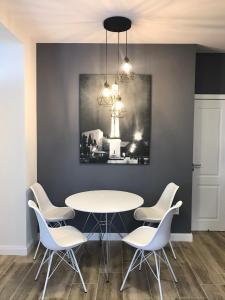 une salle à manger avec une table et des chaises blanches dans l'établissement Gabriela Central Apartment, à Satu Mare 28 autres photos