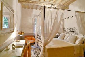 a bedroom with a canopy bed and a table at Civico 10 in Casale Marittimo