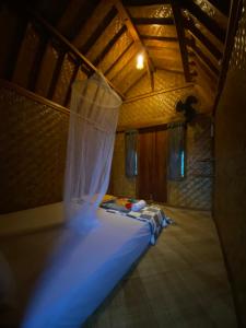a bedroom with a bed with a mosquito net at Upus Homestay in Tetebatu