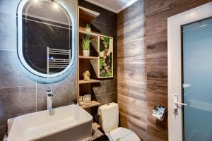 Un baño con lavabo, inodoro y espejo. en Sika Crystal Apartment Arad, en Arad 31 fotos más