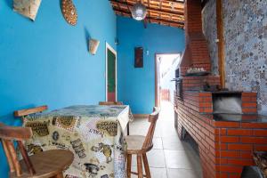 a dining room with a table and a brick oven at Casa azul, 2 quadras praia-wifi-garagem -churrasqueira e fogão a lenha - Aceita Caes -Caiçara-Praia Grande in Praia Grande +30 photos