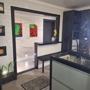 a kitchen with a sink and a tub next to a counter at Frente Mar Santos 130 m2 in Santos
