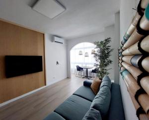 a living room with a blue couch and a flat screen tv at Apartamento céntrico con playa y piscina in Playa del Ingles