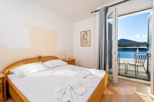 a bedroom with a bed and a view of the water at Hotel Timun in Gdinj