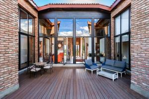a house with a deck with blue chairs and windows at Villa Chateau Artwine in Art'ana
