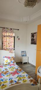 a bedroom with a large bed with a colorful blanket at Belle villa in Saly Niakh-Niakhal +20 photos