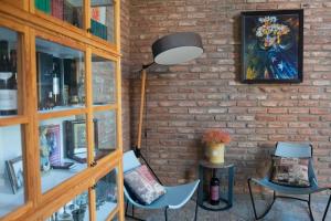 a brick wall with a lamp and two chairs at Villa Chateau Artwine in Art'ana
