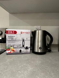 a tea kettle next to a box on a counter at Brand new suite in langley close to everything in Langley