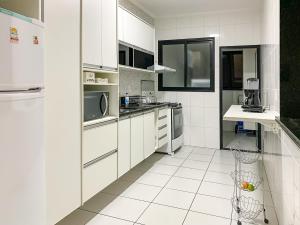 Cuisine ou kitchenette dans l'établissement Apto 3 quartos, 100m da praia, piscina e churrasqueira