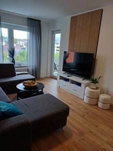 een woonkamer met een bank en een flatscreen-tv bij Busch Apartment im Zentrum in Bad Harzburg