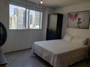a bedroom with a bed and a large window at Flat Centro de São Paulo in Sao Paulo