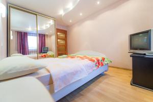 a bedroom with a large bed and a television at Five Stars Monakova in Chelyabinsk