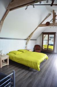 a bedroom with a green bed in a attic at La Petite Ferme in Mazé
