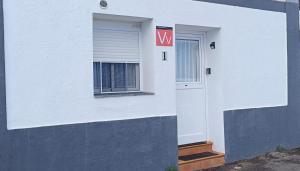 a white building with a door and a window at La Lunita in Valverde