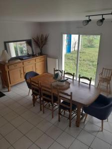 ein Esszimmer mit einem Holztisch und Stühlen in der Unterkunft Maison spacieuse proche Nantes 7 personnes in Sainte-Luce-sur-Loire