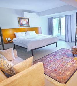 a bedroom with a large bed and a couch at The Avenue Hotel in Islamabad +50 photos