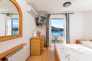 a bedroom with a bed and a mirror and a balcony at Hotel Timun in Gdinj