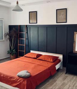 a bedroom with a bed with a red comforter at Le Rocher in Boumerdes