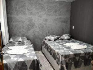 two beds sitting next to each other in a room at Sobrado para hóspedes in Guarapuava