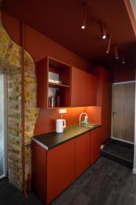 an orange kitchen with a sink and a brick wall at Kyiv Solaris Studio in Kyiv