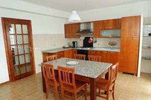 a kitchen with a table and wooden cabinets and a table and chairs at Affitti Brevi Monte Cairo in Piedimonte San Germano