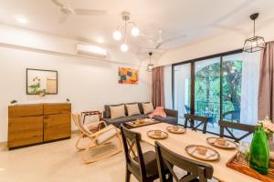 a living room with a table and a couch at Scenic 1BHK Apartment by tisyastays in Candolim
