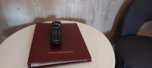 a remote control sitting on top of a book on a table at Southwell Stays in Southwell