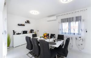a dining room with a table and black chairs at Stunning Home In Maslenica With Wifi in Maslenica