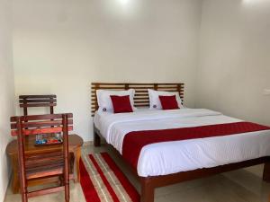 une chambre avec un lit avec des oreillers rouges et blancs dans l'établissement Luna Park & Resort, à Kottakupam