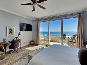 a bedroom with a bed and a desk with a view of the ocean at The Beach Club - Catalina Penthouse #2 in Gulf Highlands