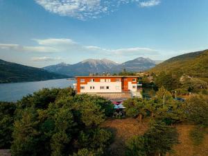 a house on a hill next to a body of water at Logis Hotel Eden Lac in Savines