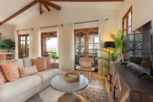 un salon avec un canapé et une télévision à écran plat dans l'établissement Mercado 26- Ocean View Condo At Las Catalinas, à Playa Danta