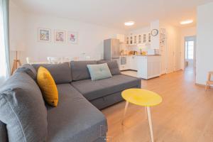 a living room with a gray couch and a kitchen at Disneyland-Paris 5 personnes, Wifi, Parking in Serris