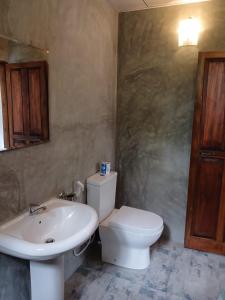 a bathroom with a white toilet and a sink at Ima House in Hiriketiya +20 photos