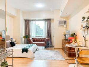 Best Staycation in BGC Central #aatft13j في مانيلا: غرفة نوم بها سرير وأريكة في الغرفة