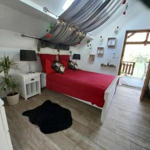 sypialnia z czerwonym łóżkiem i czerwonym kocem w obiekcie Gite avec SPA privé w mieście Drulingen
