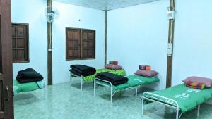a room with three beds and chairs in it at ที่ราบสูง & โฮมสเตย์ in Ban Mae Na Tai
