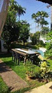 a picnic table in the grass next to a pool at Casa Colonial com Suítes e Quartos Privativos - Hospedagem Residencial in Rio Claro