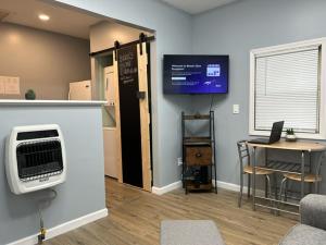 BereaBerea's Blue Bungalow - Near Hopkins Airport, IX Center, NASA, Cle MetroParks & Baldwin Wallace - Coffee Provided!的客房设有电视、桌子和书桌。 更多1张照片