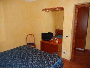 - une chambre avec un lit, un bureau et un miroir dans l'établissement Albergo Dei Leoni, à Monterotondo