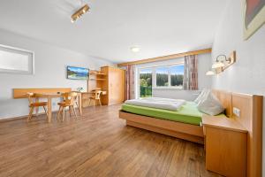 a bedroom with a bed and a table and chairs at Aparthotel Sunrise in Ramsau am Dachstein