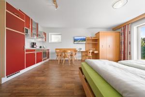 a bedroom with a large bed and a kitchen at Aparthotel Sunrise in Ramsau am Dachstein
